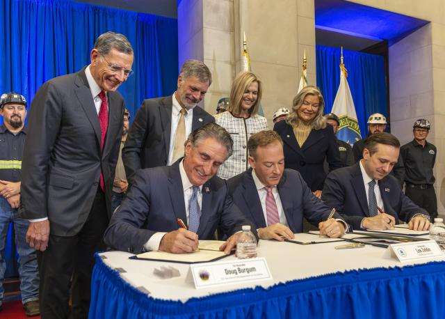 Secretary of the Interior Doug Burgum, Environmental Protection Agency Administrator Lee Zeldin, and Department of Energy Undersecretary P. Wells Griffith sit along side each other signing a coal policy initiative