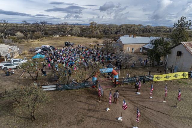 A large group of people gather near a race starting line