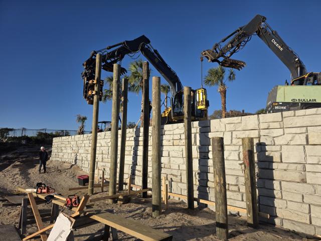 Construction equipment surrounding a rock wall