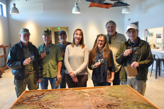 A group of people hold up America the Beautiful passes