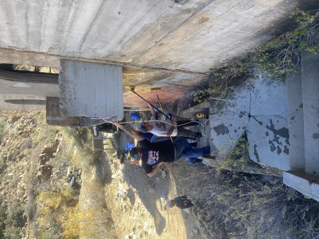 Volunteers remove graffiti from a wall.