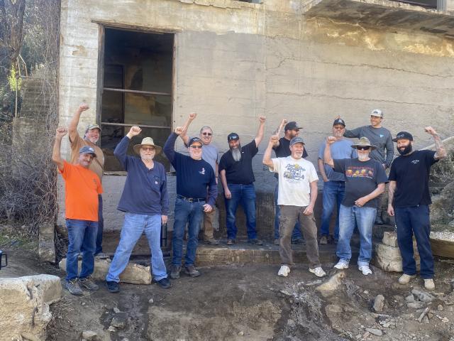 Volunteer group raise arms in celebration of completing the clean up.