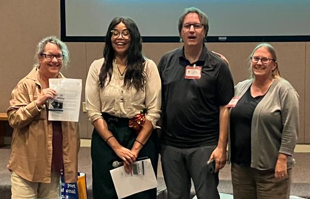 A volunteer and three other people stand together