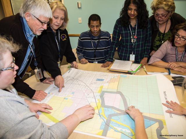 BLM employees discuss land management around a map. BLM photo.