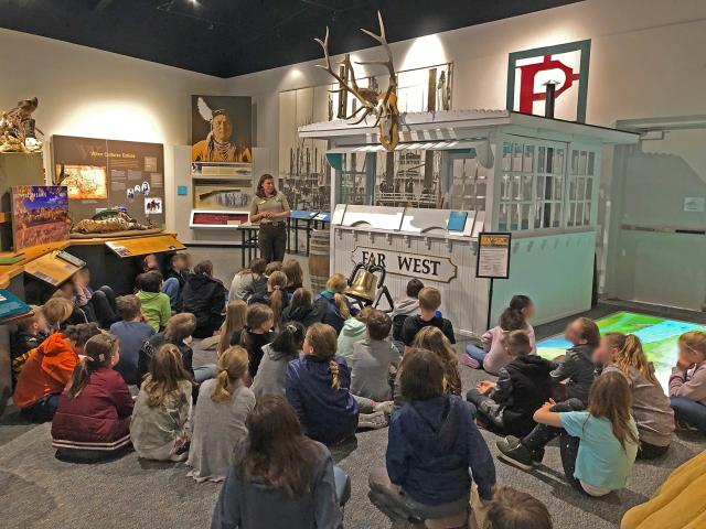 Students sit on the floor listening to a Ranger Program in the Missouri Breaks Interpretive Center