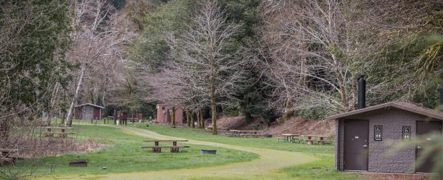 View of meadow campground sites and restroom at Edson Creek Recreation Site