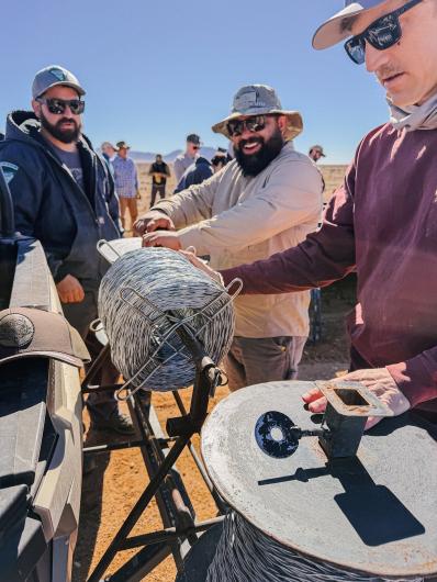 BLM staff assist in the rolling of the spools of solid replacement wire.