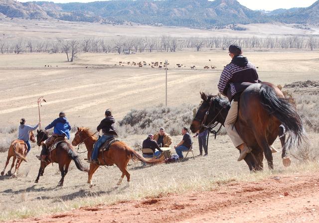 The mounted honor guard rides around the drumming circle, as part of observance activities, March 17.