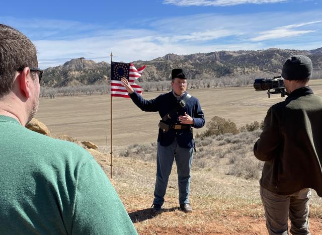 National Park Service employee Jaeger Held provided context and historical interpretation of the battle, which resulted in the court martial of Col. Reynolds and two of his officers. A local group of videographers were on hand to capture Held's presentation for a documentary. Held is dressed in a period-correct representation of the uniform issued to troopers in the year 1876.  260317
