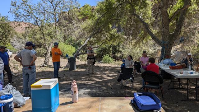 Volunteers meet in a loose circle to plan future restoration to the site.
