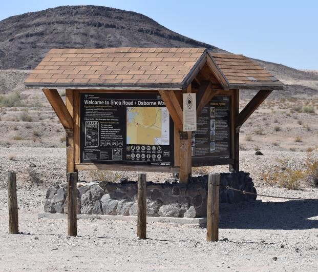 A kiosk with a hill in the desert background.