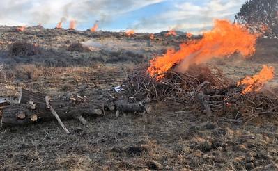 A fire burns in the dry high desert landscape.