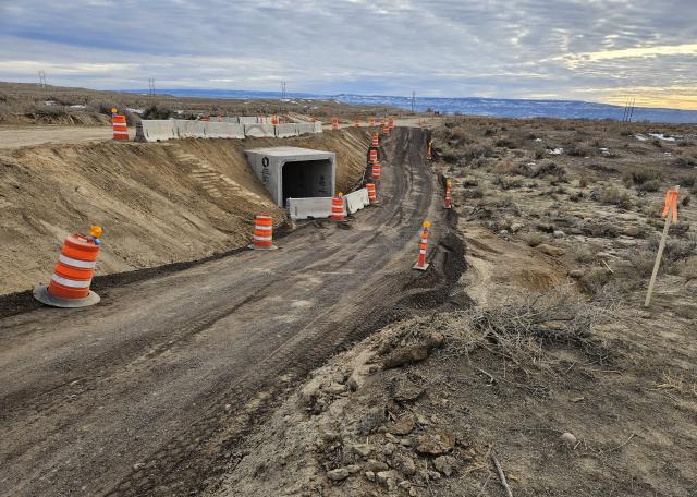 A graded road emerges from piles of dirt and concrete 