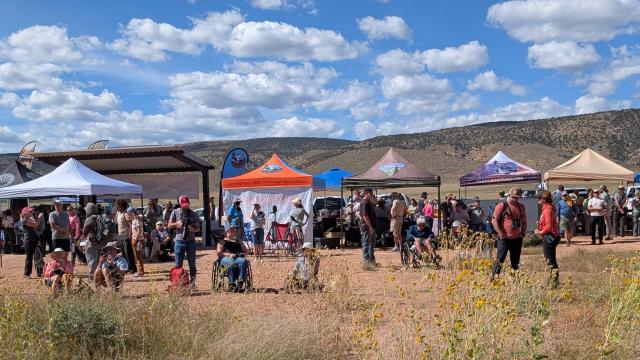 People and several pop-up shelters at an outdoor area.