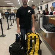 Man standing at airport counter with bags