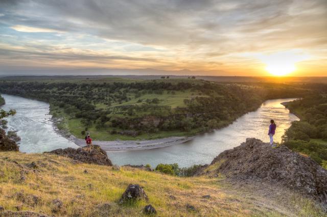 Two hikers overlooking Scremento River bend.
