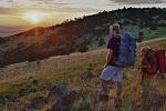hiker on hill looking out at landscape