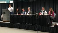 Coastal Plain Oil and Gas Leasing Program EIS Fairbanks Scoping Meeting where Joe Balash speaks to the audience from a podium on a stage with a panel of DOI, BLM, and USFWS employees.