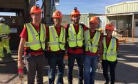 Group of five student hires smiling and wearing hard hats and bright neon vests in New Mexico