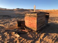 A old wooden chicken coop at a recreation site. Chicken wire and hold boards are shown.