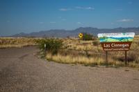 a gravel road with a sign reading Las Cienegas National Conservation Area