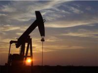 A oil and gas pump jack located in Wyoming with sunset background