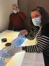 Two people at a photography light table looking at film