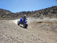 Woman rides an ATV around the bend of a trail at Fivemile Pass Recreation Area.