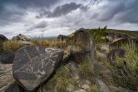 A petroglyph set against a cloudy ridge at the Three Rivers Petroglyph Site in New Mexico.