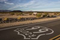 Up-close view of Route 66 with hills and brown dirt in the background.