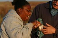 A woman petting a small rodent next to a man.