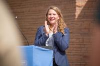 Melanie Barnes standing at the podium clapping