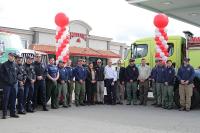 Interagency Fire Prevention partners stand in front of the Maverick store with red and white balloons and a fire truck in the background. 