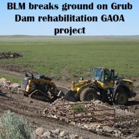 Heavy equipment digging in the ground. Text: BLM Breaks ground on Grub Dam rehabilitation GAOA Project