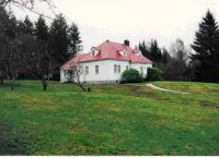 White house in grass field with trees