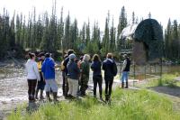 A group of people gather around a fish counting tower to learn about it.