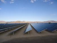 An array of long solar panels in the desert.