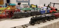 Model trains in foreground with replica town in background. 