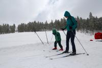 A woman and child cross country skiing. 