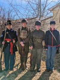 High school students in various era military uniforms. 