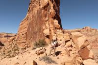 A person standing near a large rock formation.