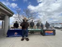 Wildfire prevention experts and Smokey Bear at an event Sunset Point Rest Area. It is a partly cloudy day.
