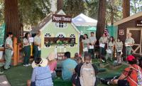Kids watching a puppet show with uniformed staff nearby