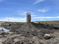 A person inspects oil and gas infrastructure left behind by an operator at an orphaned well location.