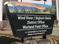 A sign that reads "Wind River/Bighorn Basin District Office Worland Field Office" sits in front of a building.