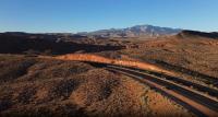 Desert landscape with road and mountains in the distance in Washington County, Utah.