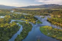 River rolling through a green, mountainous plain in Idaho.