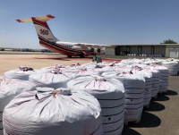 Big plastic bags on the tarmac next to a parked airplane