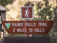 A trailhead marker that reads Rainie Falls Trail 2 Miles to Falls. 