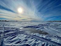 Photo. Winter snowscape. A navy-blue-colored tent set up on a frozen lake for ice fishing.